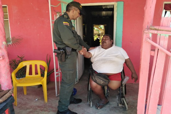 Policías entregando silla de ruedas