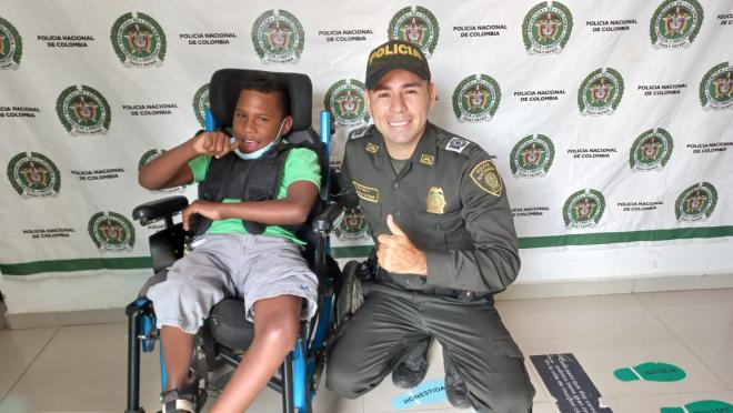 Entregando una silla de rueda a un niño con discapacidad.