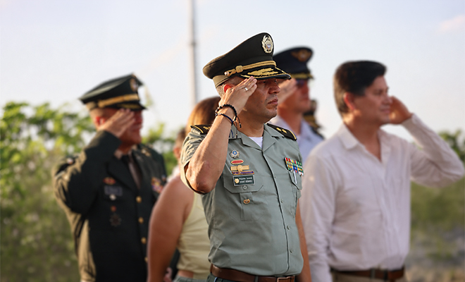 Autoridades civiles, militares y policiales participan en la ceremonia de transmisión de mando de la Policía Metropolitana de Barranquilla, durante los honores protocolarios bajo una tarima institucional.