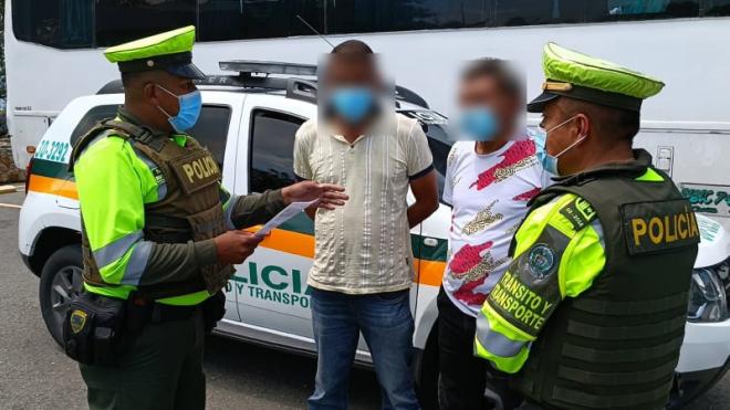 2 personas capturadas-policías custodiando