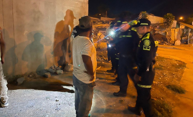 Grupo de funcionarios policiales realizando registros a personas a dos ciudadanos 