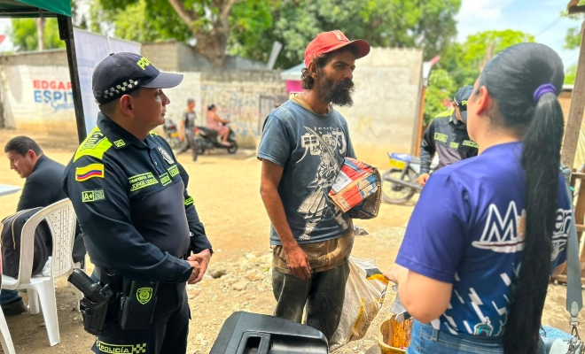 Funcionario policial y de la secretaria de salud junto a ciudadano en actividad de acompañamiento para la población en condición de calle 