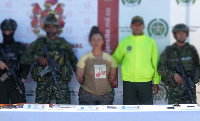 Policía y ejercito custodian una persona capturada   