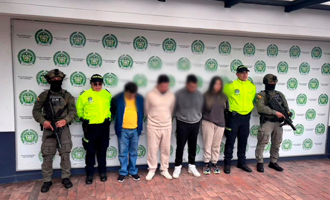 Cuatro capturados son custodiados por funcionarios de Polic&iacute;a, en un backing.