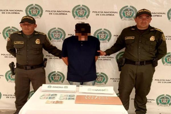 Tres personas, dos policías y un capturado en el medio 