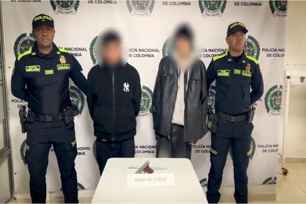 dos capturados en el centro de la foto y dos policías a los costados