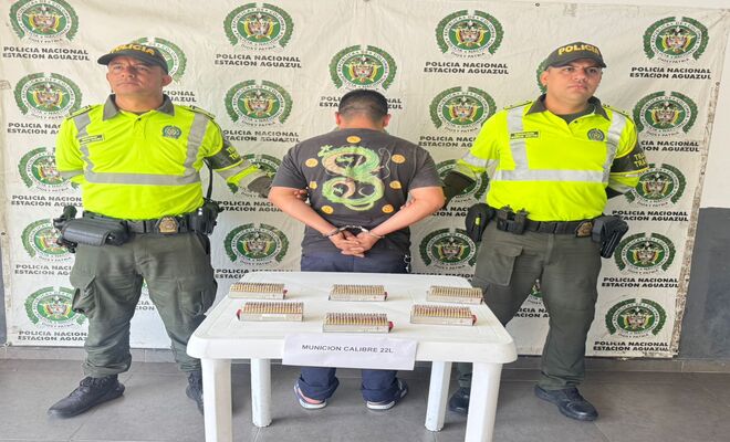 Dos polic&iacute;as, un capturado sobre la mesa 600 cartuchos de armas de fuego