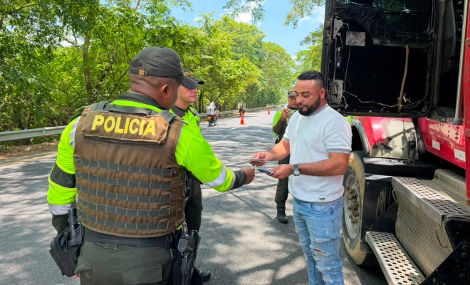 Funcionario policial de transito y transporte realizando consulta de antecedente y verificación de documento a un ciudadano 