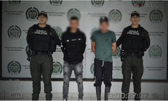 dos ciudadanos capturados, y dos policías a los lados 
