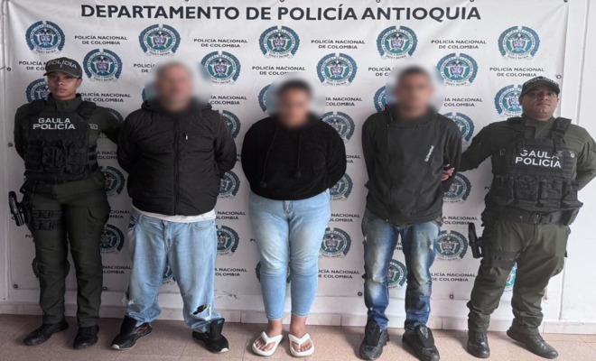 Dos policías del GAULA custodian a dos hombres y una mujer presuntos extorsionistas