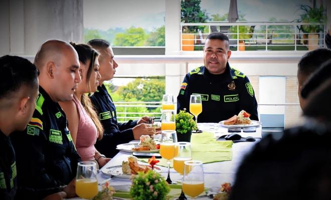 Comandante de la Metropolitana de Ibagué dialoga con policías durante un desayuno de reconocimiento.