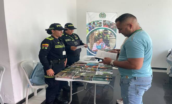 Dos policías, entregando libros de memoria a un hombre