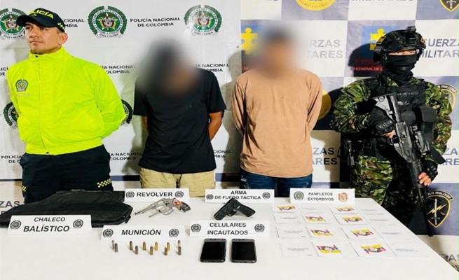 Dos capturados, una mesa con elementos incautados y dos uniformados