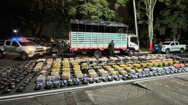 Dos uniformados de la Policía Nacional junto a aproximadamente dos toneladas de marihuana incautadas en un contundente golpe al narcotráfico.