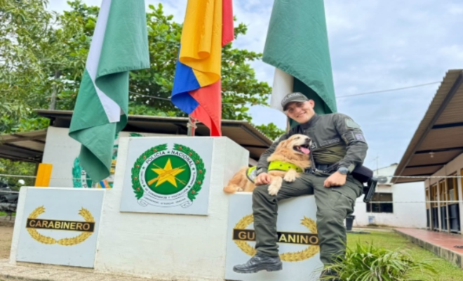 Un policía posando para una foto con su perro