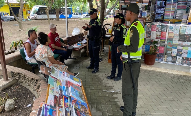 tres uniformados realizando campaña de prevención a tres ciudadanos  en establecimiento abierto al publico 
