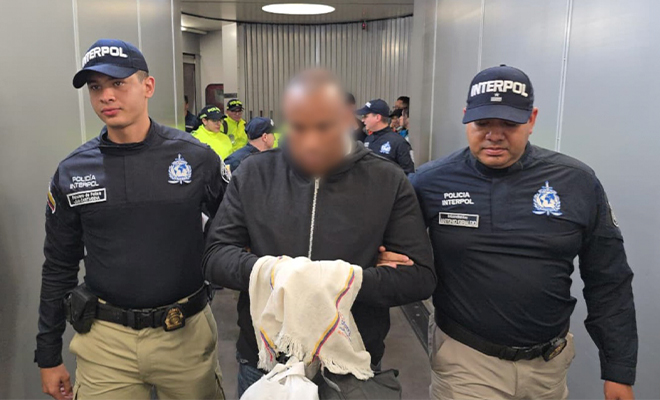 Alias 'Gustavo' es custodiado por los pasillos del Aeropuerto El Dorado, por funcionarios de INTERPOL , después de llegar extraditado de España.
