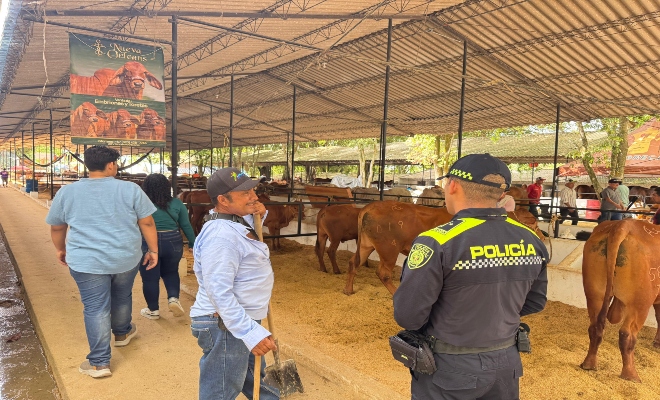 un uniformado de la policía nacional  hablando con un ciudadano sobre la seguridad en la feria nacional de la ganadería  