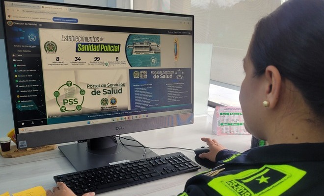 Una uniformada consulta el Portal de Servicios de Salud en un computador de escritorio