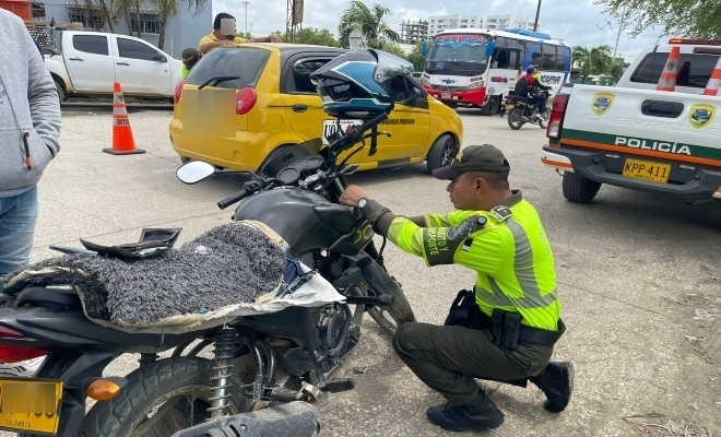 Funcionario policial de transito realizando verificación de marcaje a una motocicleta 