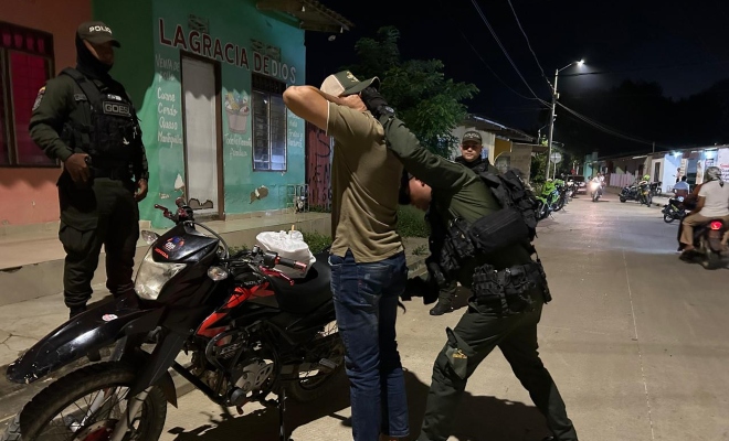 Tres funcionarios policiales realizando registro a persona a un ciudadano