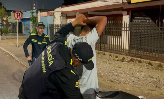 Dos funcionarios policiales realizando registro a persona a un ciudadano 
