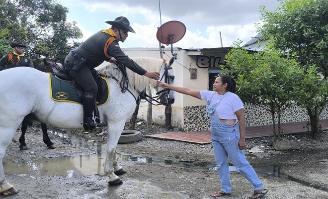 Policía brindando compañía montando a caballo a la comunidad