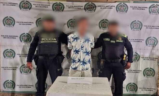 Policías, comunidad y una mesa con bolsas de estupefacientes