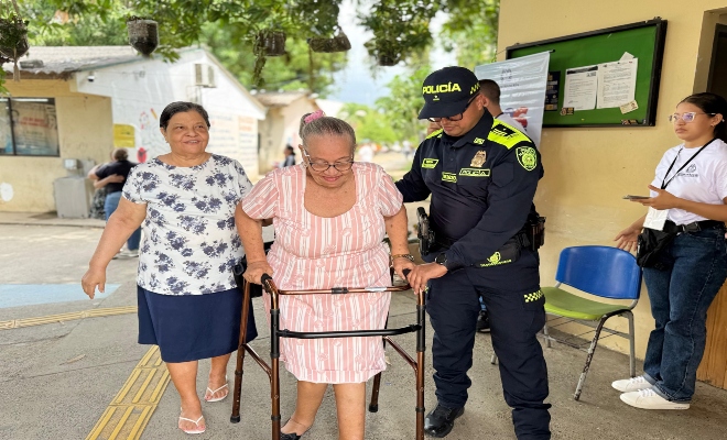 dos ciudadanas de avanzada  edad  acompa&ntilde;adas por un uniformado 