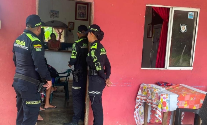 Tres funcionarios policiales realizando visitas puerta a puerta