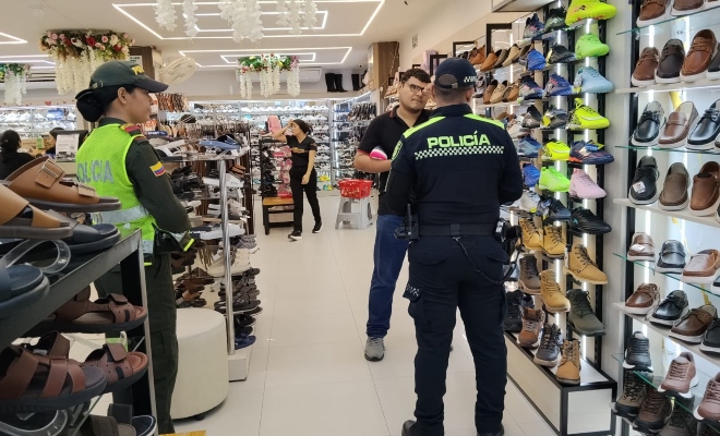 Dos funcionarios policiales junto a un ciudadano brindando recomendaciones en sector comercial