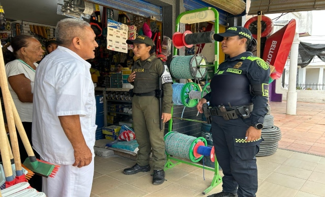 dos uniformados de la policía nacional con dos ciudadanos compartiendo  campaña de prevención en el municipio de San Carlos  
