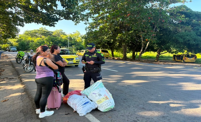 un uniformado de la Policía nacional realiza verificación de antecedentes  a ciudadanas  en el sector del kilometro 1