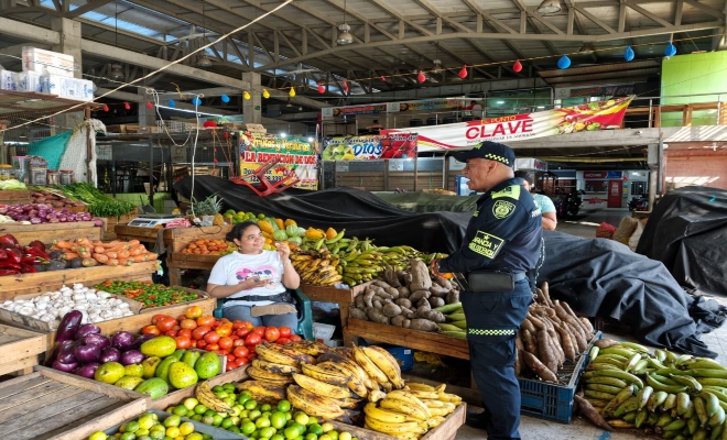 un funcionario de la Policía nacional  con una ciudadana brindándoles recomendaciones de seguridad 
