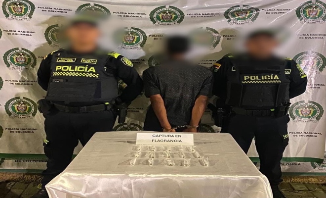 dos uniformados con una persona en calidad capturado por el delito  delito de tráfico, fabricación o porte de estupefacientes