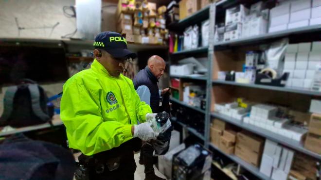 Funcionario de Polic&iacute;a Judicial, verificando los elementos de oficina hallados en los locales comerciales.