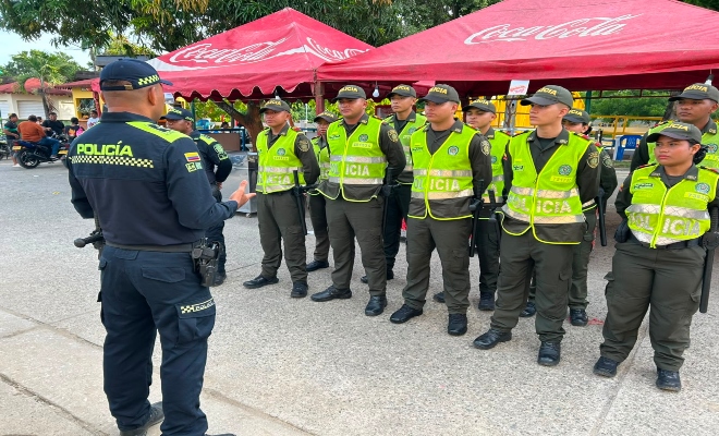 un uniformado impartiendo varias consignas a nueve auxiliares de policía  