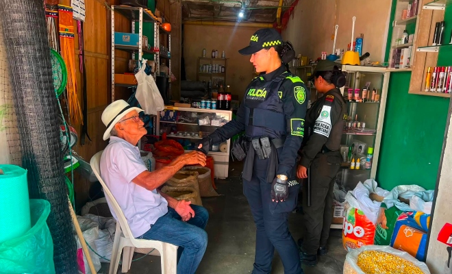 Funcionaria policial saludando a un adulto mayor en sector comercio