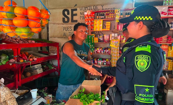 Funcionaria policial saludando a un ciudadano en sector comercio