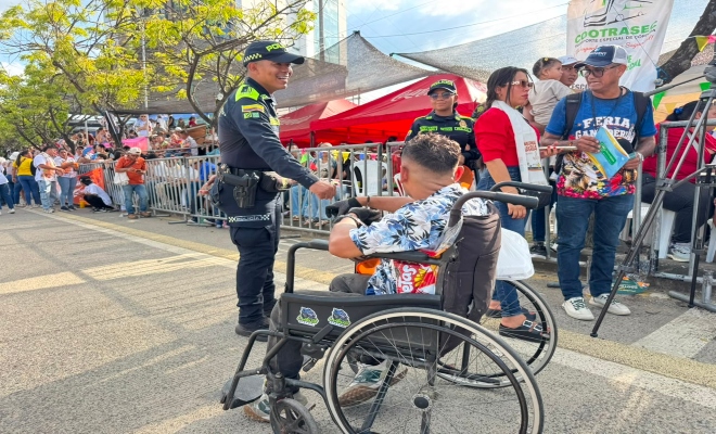 dos uniformados brindando recomendaciones a ciudadanos que visitan  la gran parada  folclórica en la ciudad de montería  