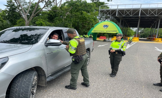 un polic&iacute;a saludando a la comunidad y un polic&iacute;a prestando seguridad 