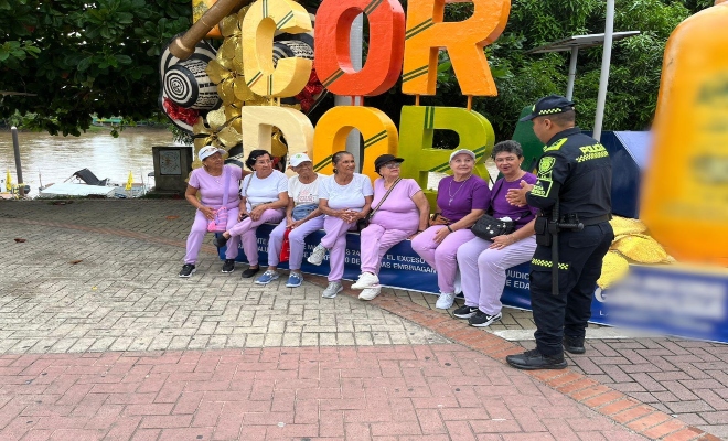 un uniformado brindando recomendaciones a siete ciudadanas en el parque principal de la ciudad de Monter&iacute;a
