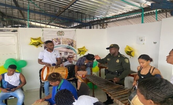 Un policía explicando cómo utilizar un instrumento musical.