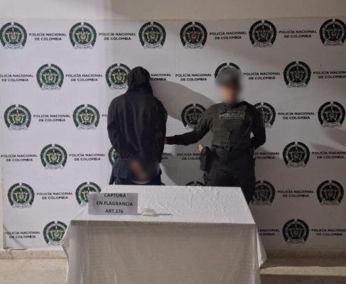 Una mujer policía junto a un hombre capturado
