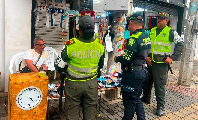 Funcionario policial con dos auxiliares de policía brindando recomendaciones de a un ciudadano