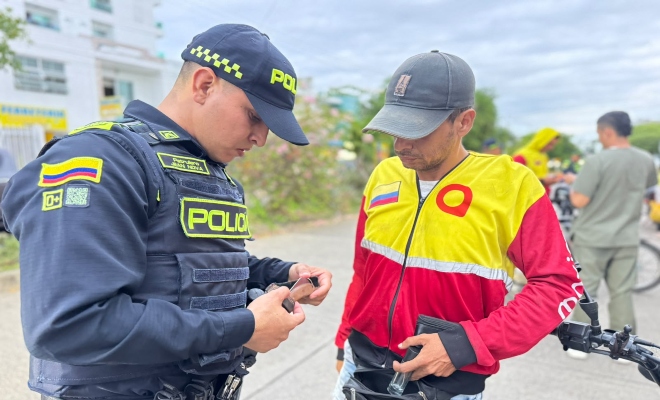 Funcionario policial realizando actividad de registro a las pertinencias de un ciudadano