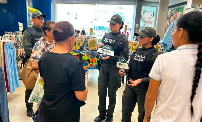 Tres funcionarios policiales brindando recomendaciones de seguridad a tres ciudadanas en sector comercial