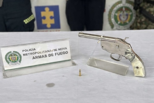Arma de fuego tipo revolver en primer plano con un cartucho