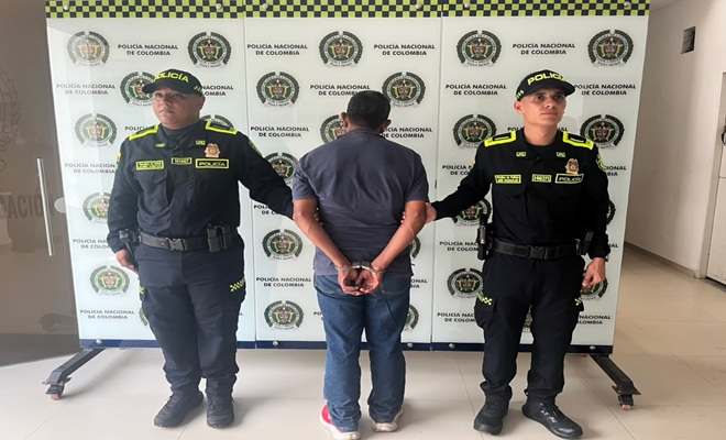 Dos Polic&iacute;as prestando seguridad a un hombre capturado por orden judicial en Barrancabermeja.