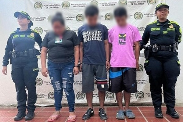 Funcionario de la SIJIN leyendo los derechos del capturado y dos Policías con los tres capturados por el delito de tráfico de estupefacientes